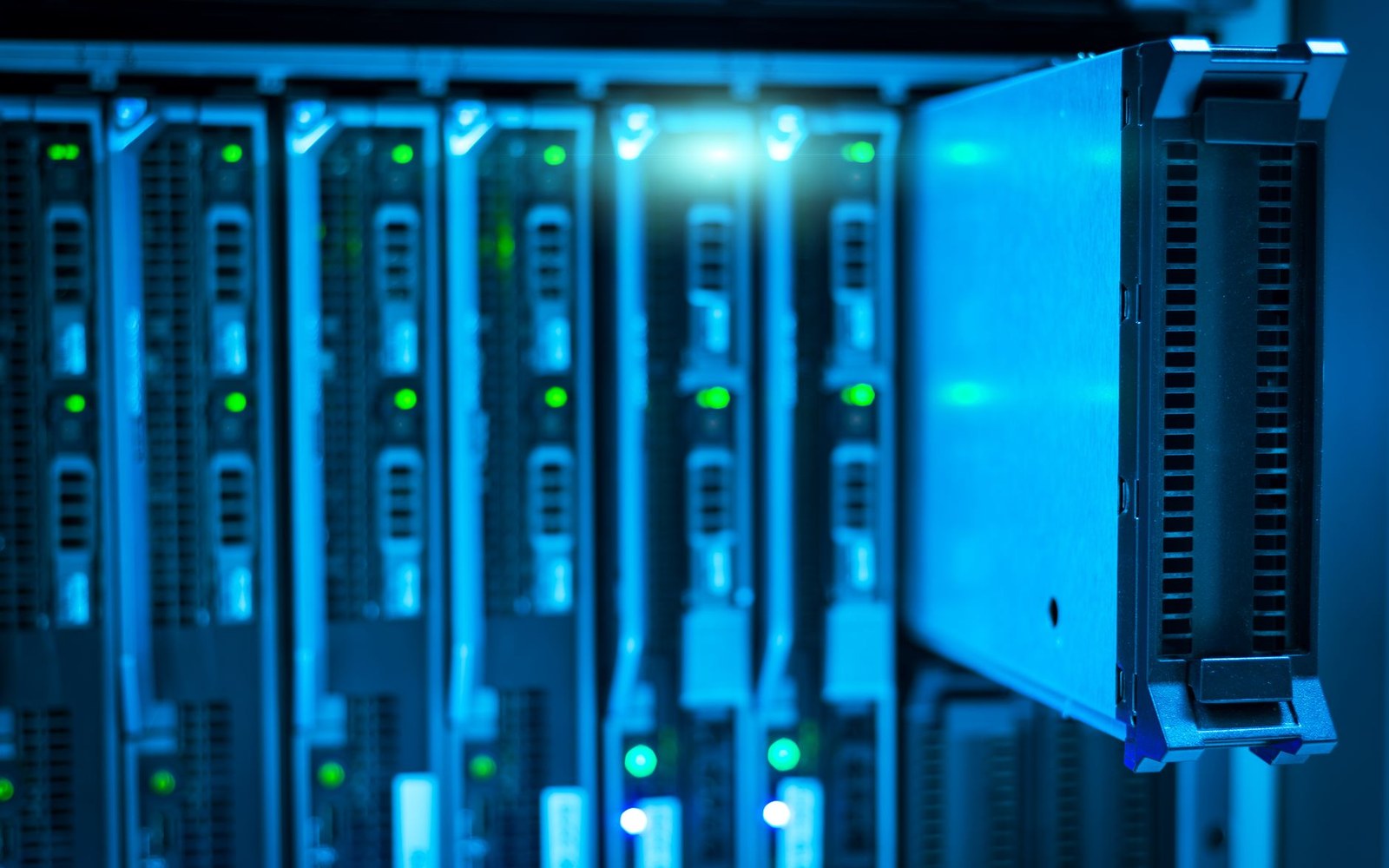 A data-centre aisle in cool blue-white light with rack indicator lights receding